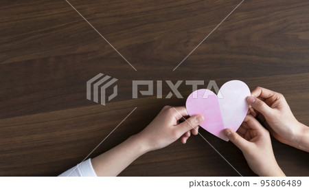 Family hands holding a heart 95806489