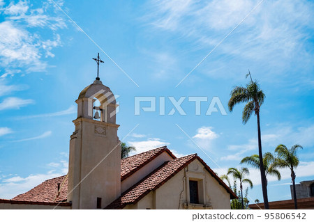 La Jolla Spanish mission style church bell tower with palm trees in San diego California. Religious symbolism of mexican culture 95806542