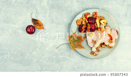Pork shoulder baked with vegetables and plums. 95807343