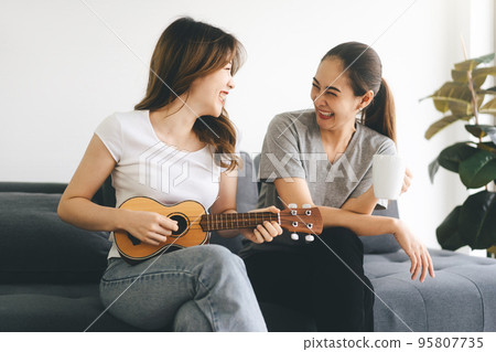 Two young adult woman living together with relationship relax lifestyle at home 95807735