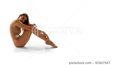 Portrait of beautiful woman posing in beige bodysuit over white studio background. Flyer. Taking care after skin 95807847