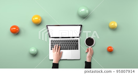 Person using a laptop computer with abstract spheres 95807914