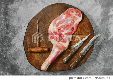 Raw lamb shoulder chump on butcher's cutting log 95808044