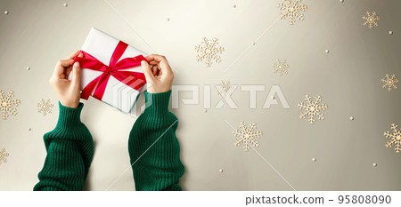 Person making a Christmas gift box 95808090