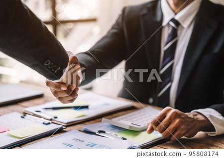 Business people shaking hands, finishing up a meeting. 95808174