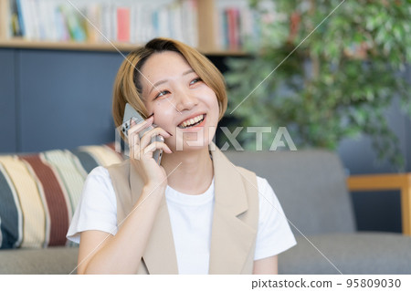 一個微笑的少婦談話在智能手機 95809030