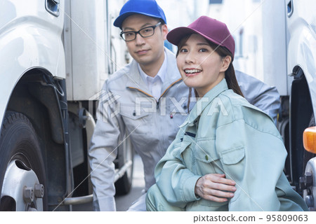 檢查卡車輪胎的男性和女性司機 95809063