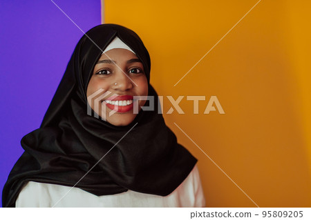 Muslim woman with a beautiful smile wearing a hijab poses in the studio Muslim woman with a beautiful smile wearing a hijab poses in the studio 95809205