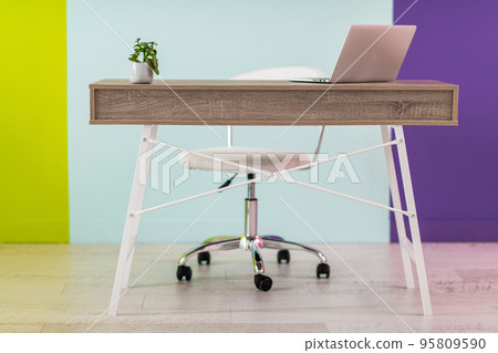 Modern furniture in front of a colorful background with a laptop 95809590