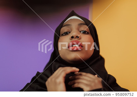 Muslim woman with a beautiful smile wearing a hijab poses in the studio 95809752