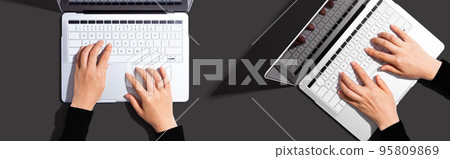 Two people working together with laptop 95809869