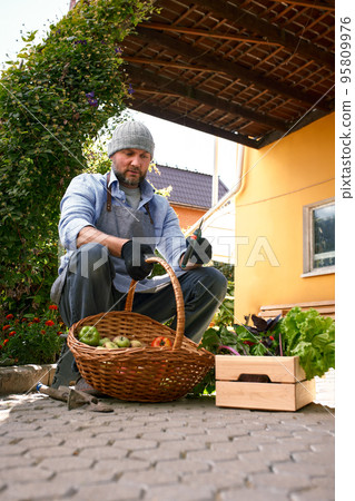 A male farmer sitting in the yard outdoors, resting. A male farmer sitting in the yard outdoors, resting. 95809976