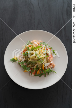 Fettuccine pasta with crab and arugula on black wood table 95810661
