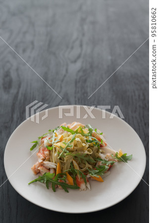 Fettuccine pasta with crab and arugula on black wood table 95810662