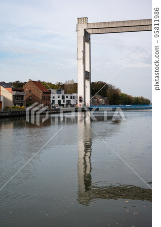 Humbeek, Flemish Brabant Region, Belgium, Suspension bridge at the sea canal with residential houses reflecting in the water 95811986