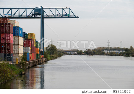 Zemst, Flemish Brabant Region, Belgium, Cargo containers and industrial crane at the harbor of the river Durme Zemst, Flemish Brabant Region, Belgium, Cargo containers and industrial crane at the harbor of the river Durme 95811992