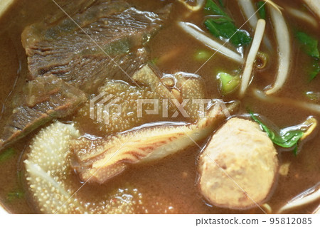 boiled braised beef and meatball in black herb soup on bowl 95812085