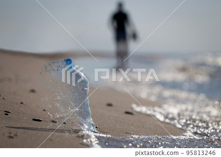 Creartive concept, garbage left on a sandy beach. Close-up, selective focus, PET blue plastic bottle. Creartive concept, garbage left on a sandy beach. Close-up, selective focus, PET blue plastic bottle. 95813246