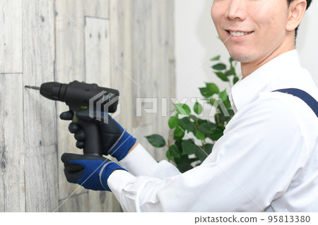 A young man in a young apron doing DIY A young man in a young apron doing DIY 95813380