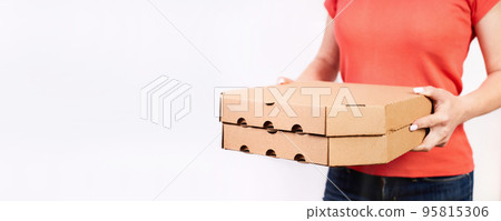Girl delivering pizza in cardboard boxes on a white background with copy space 95815306
