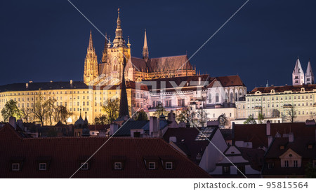 Night panorama with castle above historical city illuminated, narrow shot, Prague, Czechia Night panorama with castle above historical city illuminated, narrow shot, Prague, Czechia 95815564