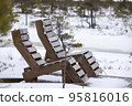 Wooden chairs in the snow by a frozen lake 95816016