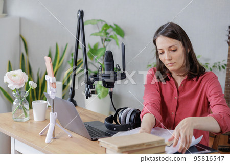 woman in a home office records podcast audio content with a microphone and headphones and a labrador dog woman in a home office records podcast audio content with a microphone and headphones and a labrador dog 95816547