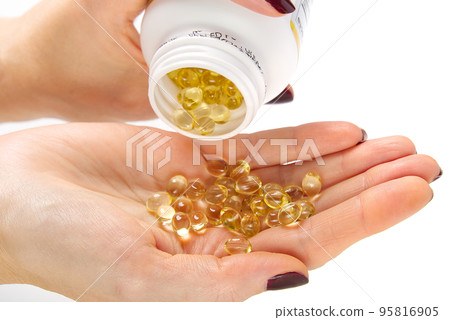 Women hand with gel capsules of D Vitamin . Vitamin Omega-3 fish oil in capsules. hand holding gelcap or softgel transparent capsule pills Women hand with gel capsules of D Vitamin . Vitamin Omega-3 fish oil in capsules. hand holding gelcap or softgel transparent capsule pills 95816905