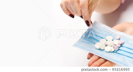 concept covid vaccine pills. COVID-19. Medical mask on a hand with white background. Medicine pills or Vaccine against the virus. concept covid vaccine pills. COVID-19. Medical mask on a hand with white background. Medicine pills or Vaccine against the virus. 95816995