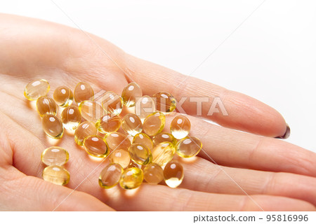Women hand with gel capsules of D Vitamin . Vitamin Omega-3 fish oil in capsules. hand holding gelcap or softgel transparent capsule pills Women hand with gel capsules of D Vitamin . Vitamin Omega-3 fish oil in capsules. hand holding gelcap or softgel transparent capsule pills 95816996
