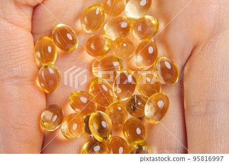 Women hand with gel capsules of D Vitamin . Vitamin Omega-3 fish oil in capsules. hand holding gelcap or softgel transparent capsule pills Women hand with gel capsules of D Vitamin . Vitamin Omega-3 fish oil in capsules. hand holding gelcap or softgel transparent capsule pills 95816997