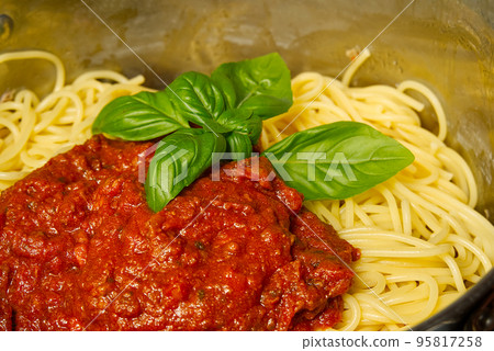 Add bolognese sauce on spaghetti in pot. cooking pasta bolognese at home Add bolognese sauce on spaghetti in pot. cooking pasta bolognese at home 95817258