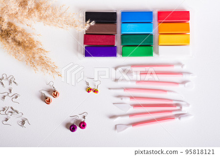 Multi-colored polymer clay and tools for making earrings. Top view. Multi-colored polymer clay and tools for making earrings. Top view. 95818121