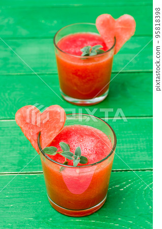Fresh watermelon blended drink with mint leaves and a heart of watermelon in glasses on a wooden table. Ready-to-eat drink 95818398