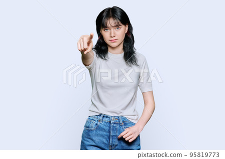 Displeased angry young woman pointing finger at camera, white background 95819773