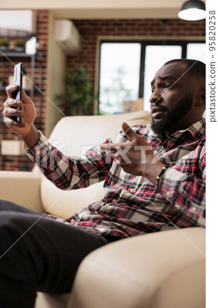 Adult attending online videocall conference, using smartphone app to talk to people on videoconference call. Freelancer chatting on remote teleconference business meeting on mobile phone. 95820258