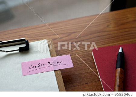 A desk with a sticky note that says Cookie Policy 95820463