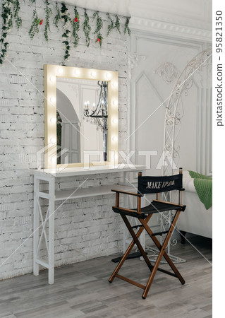 Table with makeup products and mirror near white wall, space for text. Dressing room interior Table with makeup products and mirror near white wall, space for text. Dressing room interior 95821350