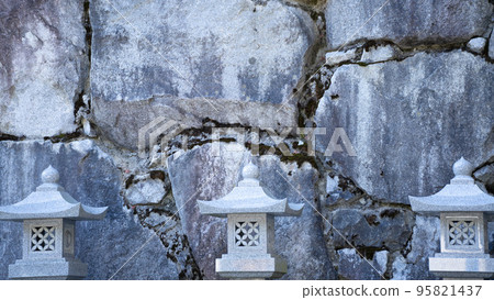 Autumn temple stone wall lined with many lanterns 95821437