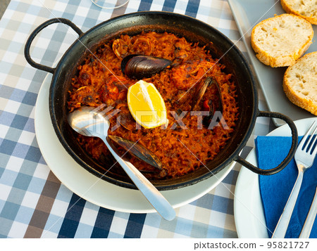 Traditional Valencian seafood paella with shrimps, squid and clams Traditional Valencian seafood paella with shrimps, squid and clams 95821727