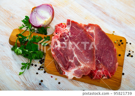 Raw pork chop on cutting board 95821739