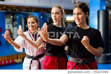 Three young smiling women practicing in karate Three young smiling women practicing in karate 95821986