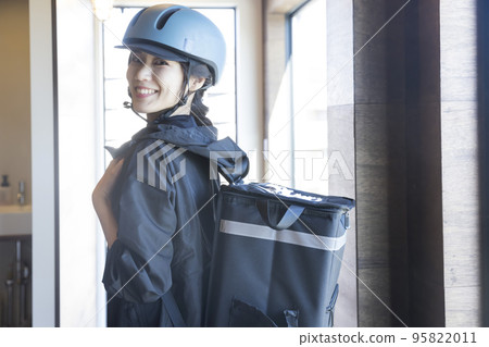 Food delivery image A young woman who is a delivery staff member leaving the store Shared deli 95822011