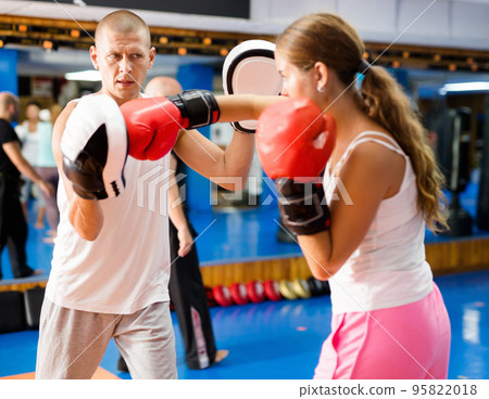 Woman and trainer exercising hooks 95822018