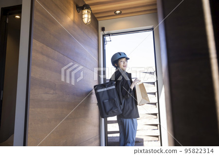 Food delivery image A young female delivery staff who leaves the store after picking up the items Shared deli 95822314