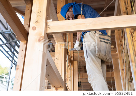 A plasterer making a groundwork for an earthen wall 95822491