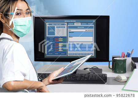 Female doctor working on electronic medical record with a desktop computer. 95822678