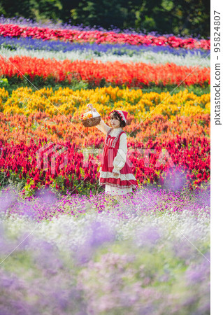 一個花園和一個打扮成小紅帽的女人 95824807