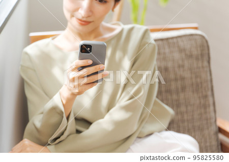 A woman watching a smartphone A woman watching a smartphone 95825580
