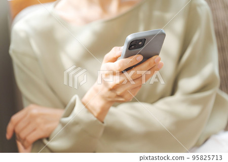 A woman watching a smartphone 95825713